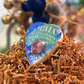 Summon Your Inner Goddess bath bomb with a large carnelian or amethyst crystal visible on top through the viewing window, Good Common Sense Naturals