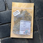 A package of Breathe Facial Steam herbal blend with a label showing the product name, placed on a black tiled surface.