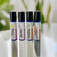 Set of 4 essential oil roller bottles  Immunity, Roller Tension, Focus, and Unwind in a line. on a glass table 
