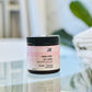 black jar labeled Hot Mess, Damaged Hair Treatment, on glass table