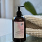 A pump bottle of Curly Hair Shampoo with a label indicating it is protein rich and has lavender and rosemary scents.