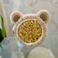 bear looking head band wrapped around a large sea sponge on a glass table 