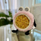 pink headband with eyes having spirals inside them. wrapped around a large sea sponge 
