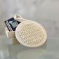 Washable Facial Exfoliating Disk laying on a wood soap dish 