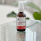 A pump bottle of All The Things Multi-Purpose Ointment on a reflective surface, with a white label and red text.