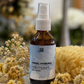 Herbal helichrysum hydrosol bottle with flowers and a sponge on a marble surface
