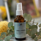 Eucalyptus hydrosol bottle with eucalyptus leaves on a marble surface