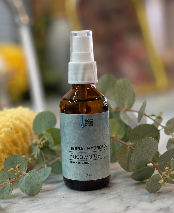 Eucalyptus hydrosol bottle with eucalyptus leaves on a marble surface