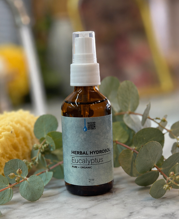 Eucalyptus hydrosol bottle with eucalyptus leaves on a marble surface