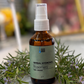 Bottle of herbal hydrosol with rosemary on a marble surface