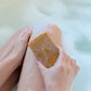 Person scrubbing leg with a bar of soap in a bathtub