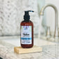 A pump bottle of Native Body Lotion - Signature Spa on a marble surface with a kitchen background.