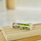A tube of lip balm labeled 'Choco Mint' placed on a wooden lip balm holder, with a blurred background.