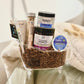 A gift set containing various foot care products, including a pedicure brush, shower tab, grow n glow pen, handy, and bath salt, arranged in a clear container with a towel and a tag.