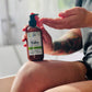 a person pumping out lotion from a brown bottle with a green label 