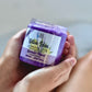 two hands holding a purple scrub labeled olive you