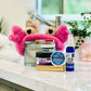 Spa on the Go Gift Set with pink head band, lip balm, mud face mask, sugar scrub, showder steam tab, and facial cream. 