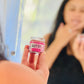 A close-up image of a person holding a small container of Beet It Sugar Lip Scrub, with the container clearly showing the product name.