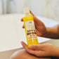 A clear plastic bottle of Bubbles Up! High Pine Body Wash being held in a person's hand.