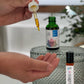 hand holding a dropper. one dropper bottle and rollor bottle in background labeled clarity