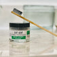 clear jar with the labeled eat dirt with a tooth brush on top 