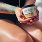 women holding a white jar labeled muddy butts 