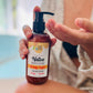 A pump bottle of Native Body Lotion - Simply Joyful, held in a person's hands.