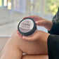 A jar of Oh My Buttah - Mandarin Dream whipped body butter being held by a person seated 