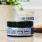 A jar of Oh My Body Butter, which is a whipped body butter with a label indicating organic shea butter, aloe, and essential oils.
