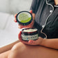 A person sitting cross-legged, holding a jar of body butter in one hand and its lid in the other, with the product name 'Oh My Buttah - Signature Spa' visible on the lid.