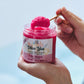 hand holding a spoon scooping out a pink sugar scrub labeled olive you