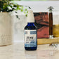 A bottle of Prime Cool Mint pre-shave oil with a spray nozzle, placed on a marble surface in a home environment.
