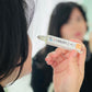 Girl about to pply the vibrance serum to face. with a blured backround 