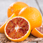A photo of several clementine fruits, one of which is cut in half to show the inside, placed on a textured surface.