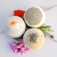 set of 3 bath bombs on a couple of flowers 