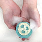 A person's hands holding a bar of eucalyptus soap, with bubbles forming around the soap.