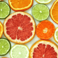 A collection of various citrus fruits including bergamot, tangerine, and grapefruit, cut in half to show the interior.