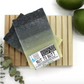 grey and white bar of soap labeled nut to butt on a wooden soap saver 